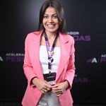 Greice Laurentino da Silva Proprietária - Maislaser Piracicaba usando blazer rosa, sorrindo, em frente a um painel de cor preto
